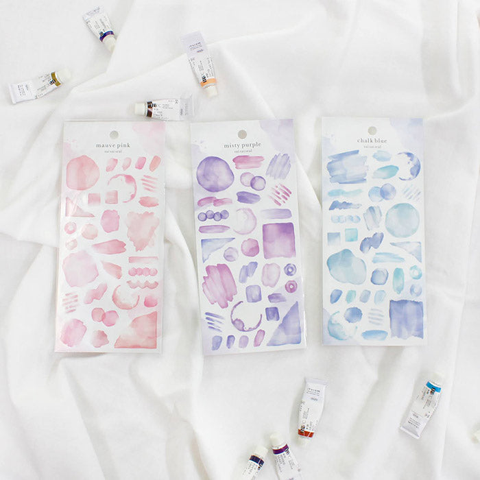 Mind Wave Sui Sai Watercolor Stickers Chalk Blue These stickers are perfect for all paper projects, adding a unique touch with their transparent watercolor look. Spice up your planners, cards, and more with these elegant and artistic stickers.