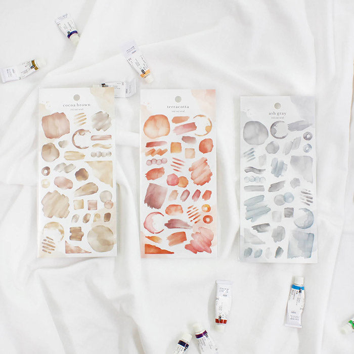 Mind Wave Sui Sai Watercolor Stickers Cocoa Brown These stickers are perfect for all paper projects, adding a unique touch with their transparent watercolor look. Spice up your planners, cards, and more with these elegant and artistic stickers.