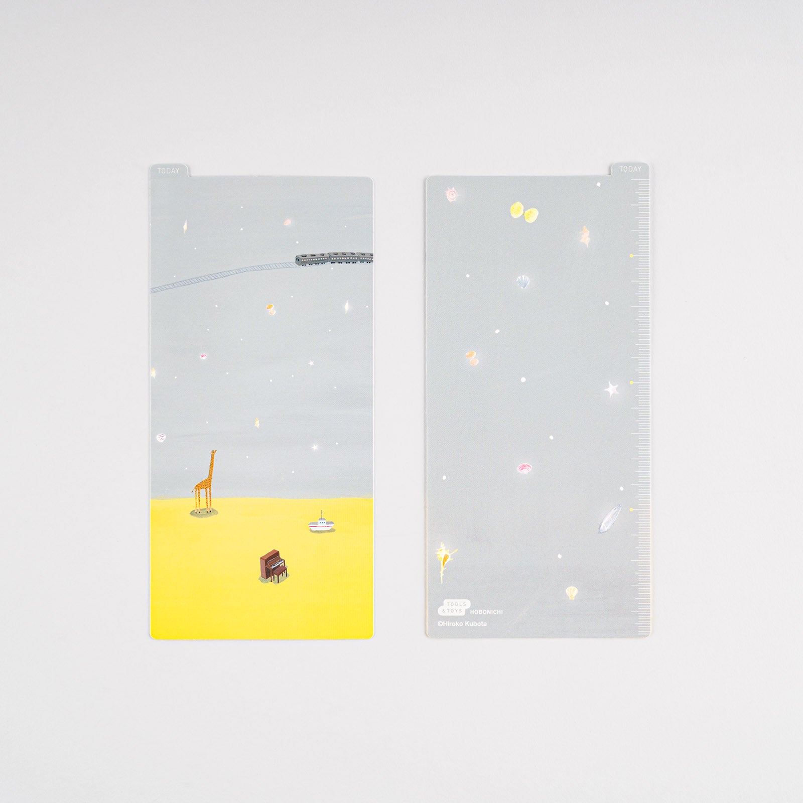 Hobonichi Hiroko Kubota: Pencil Board for Weeks (Twinkle-shells) This pencil board features artwork by Hiroko Kubota. The Hobonichi pencil boards are designed to use underneath the page you are writing on to keep your writing experience even smoother.