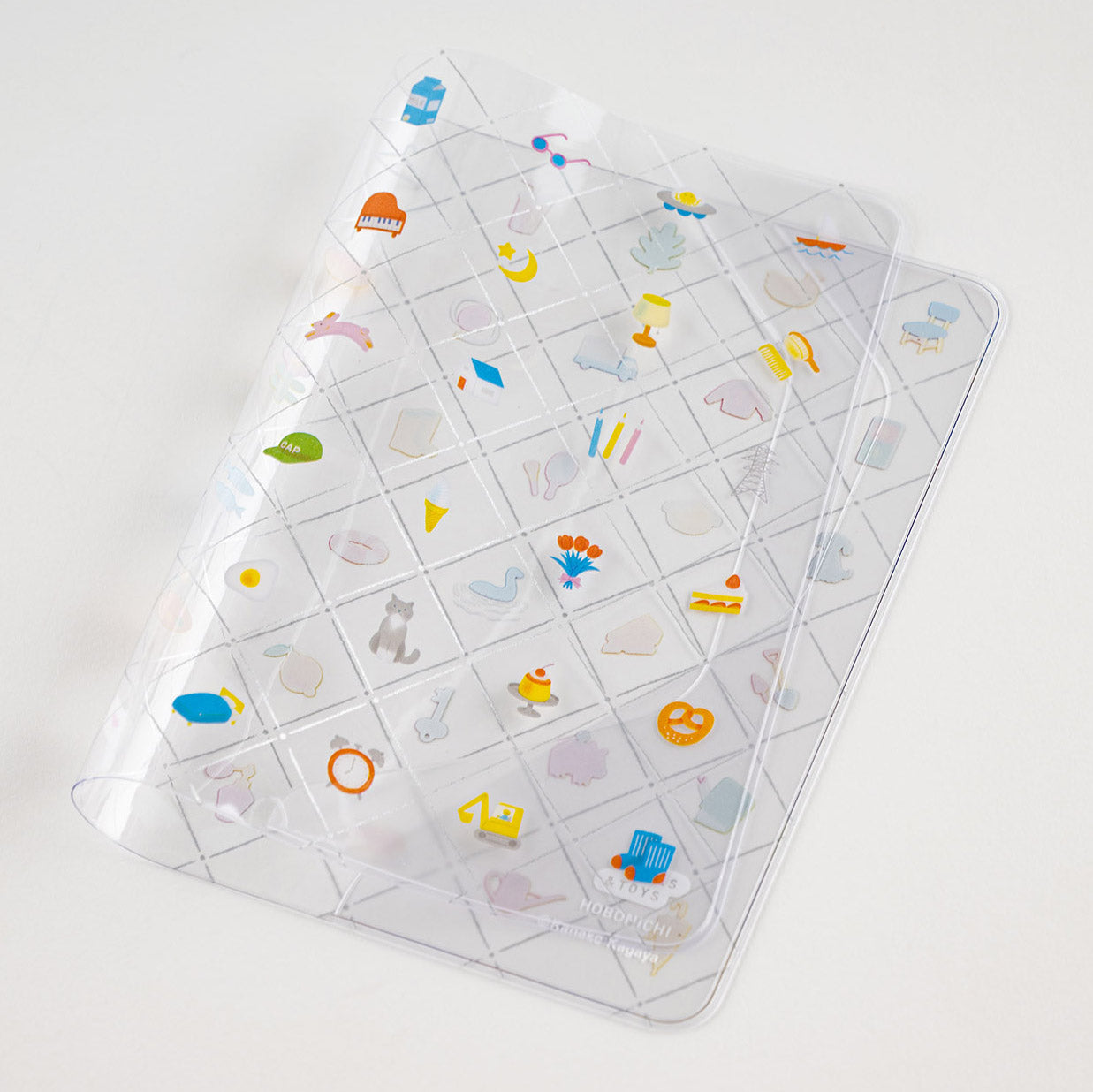 Hobonichi Kanako Kagaya: Cover on Cover for A6 Size (Familiar Sights) Cover on cover is a protective cover that can be used on top of your Hobonichi cloth covers to protect them from wear and tear. This product can not be used on top of the book only. You can also store illustrations under your cover on cover to boost your Hobonichi covers design. The design for “Familiar Sights” was created by designer and illustrator Kanako Kagaya.